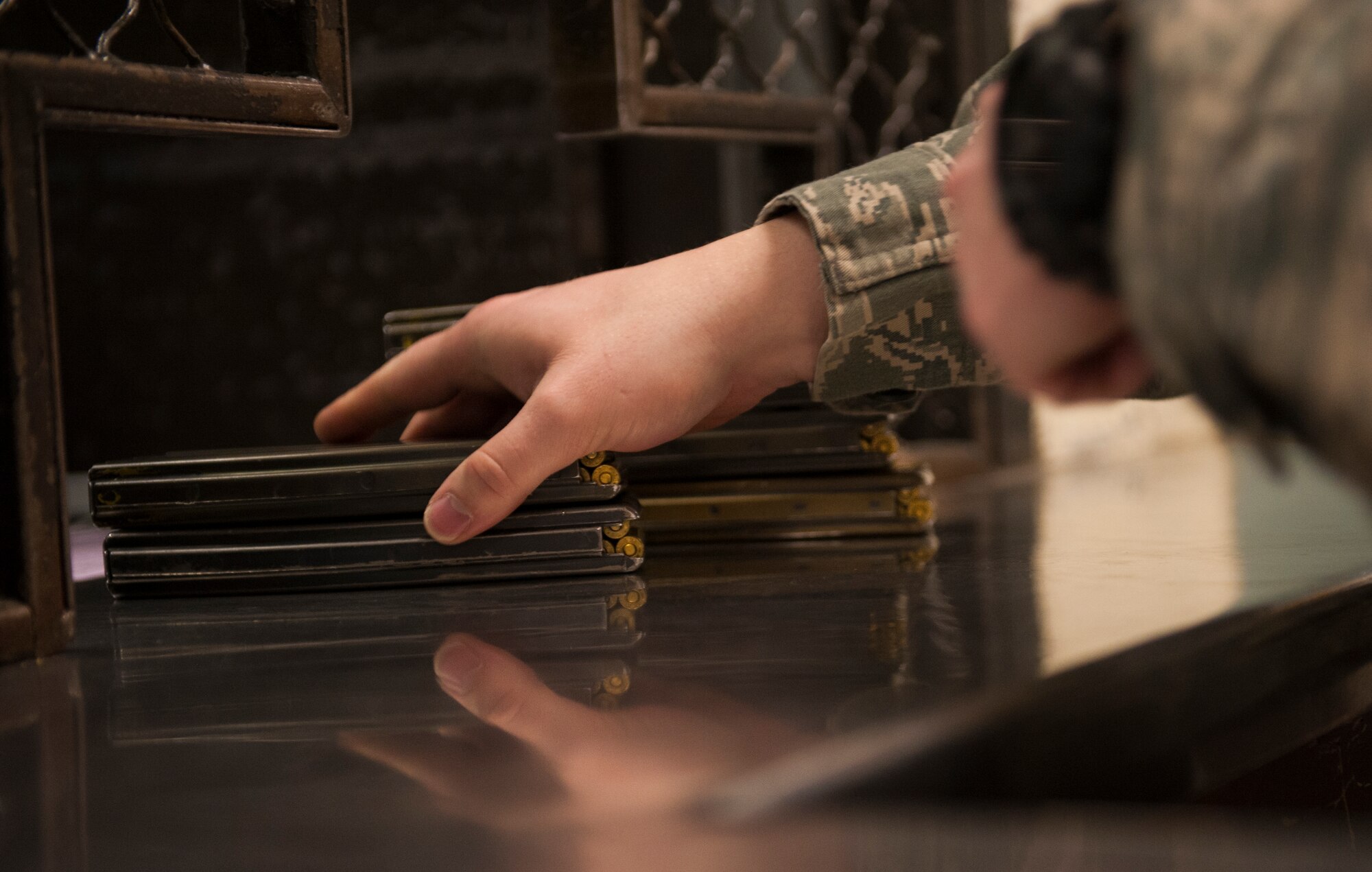 An Airman from the 5th Security Forces Squadron reaches for his ammo magazines at Minot Air Force Base’s armory window, Jan. 13, 2014. Security forces Airmen are issued the proper weapons for their shift at the armory. (U.S. Air Force photo/Airman 1st Class Apryl Hall)