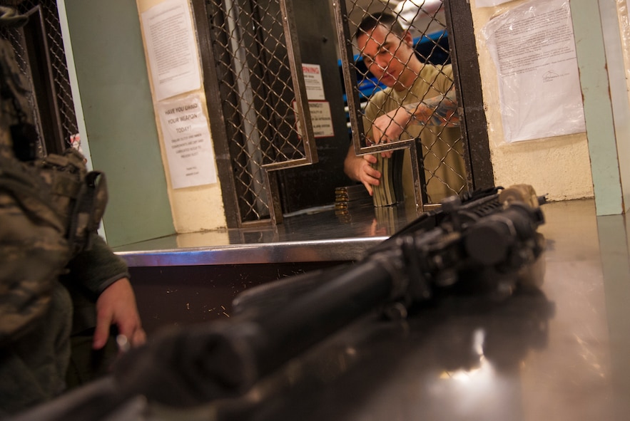 Senior Airman Tim Lobuglio, 5th Security Forces Squadron staff armor, issues a weapon and ammo magazines to a security forces Airman at Minot Air Force Base’s armory, Jan. 13, 2014. Staff armors are responsible for weapons issue and return during every security forces shift change. (U.S. Air Force photo/Airman 1st Class Apryl Hall)