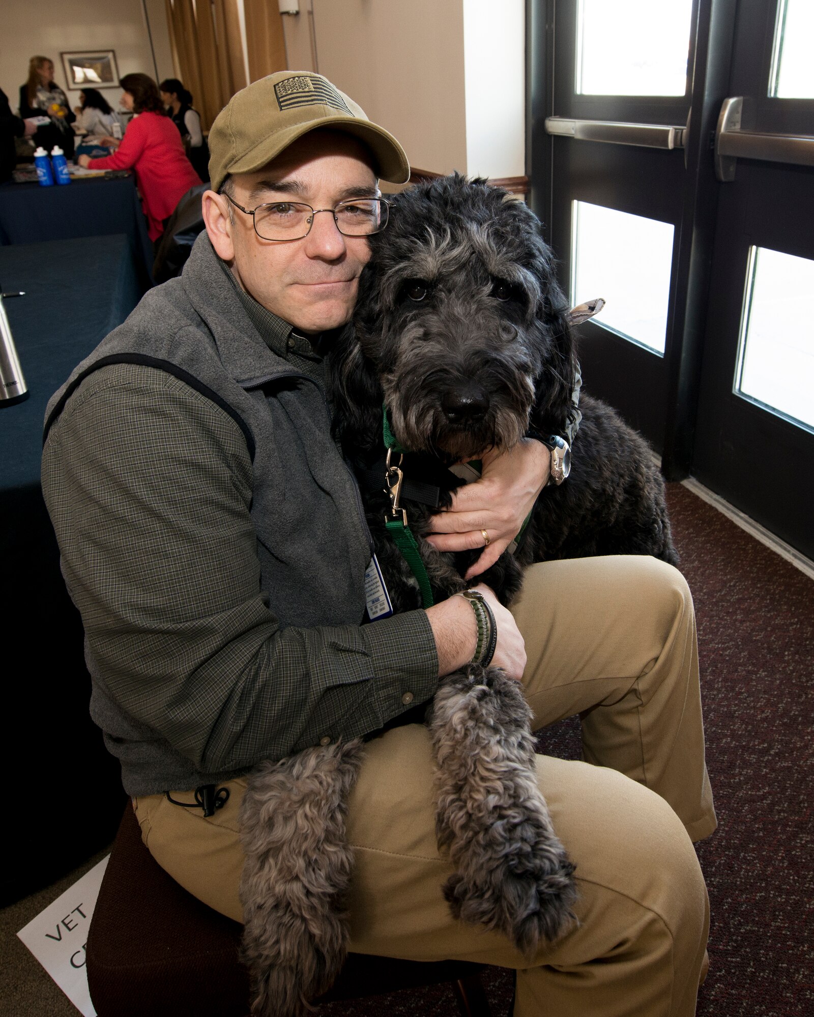 Mr. James Becker, Buffalo Vet Center Outreach Counselor and Service Dog Jazzy represent the Buffalo Vet Center table at the Wellness Seminar being held at the Niagara Falls Air Reserve Station, January 15, 2014, Niagara Falls NY. Over twenty vendors participated in this one day seminar hosted by the base that offered chair massages, bone density screening, nutrition info, smoking cessation, financial wellness, animal therapy and more. (U.S. Air Force photo by Tech. Sgt. Joseph McKee)