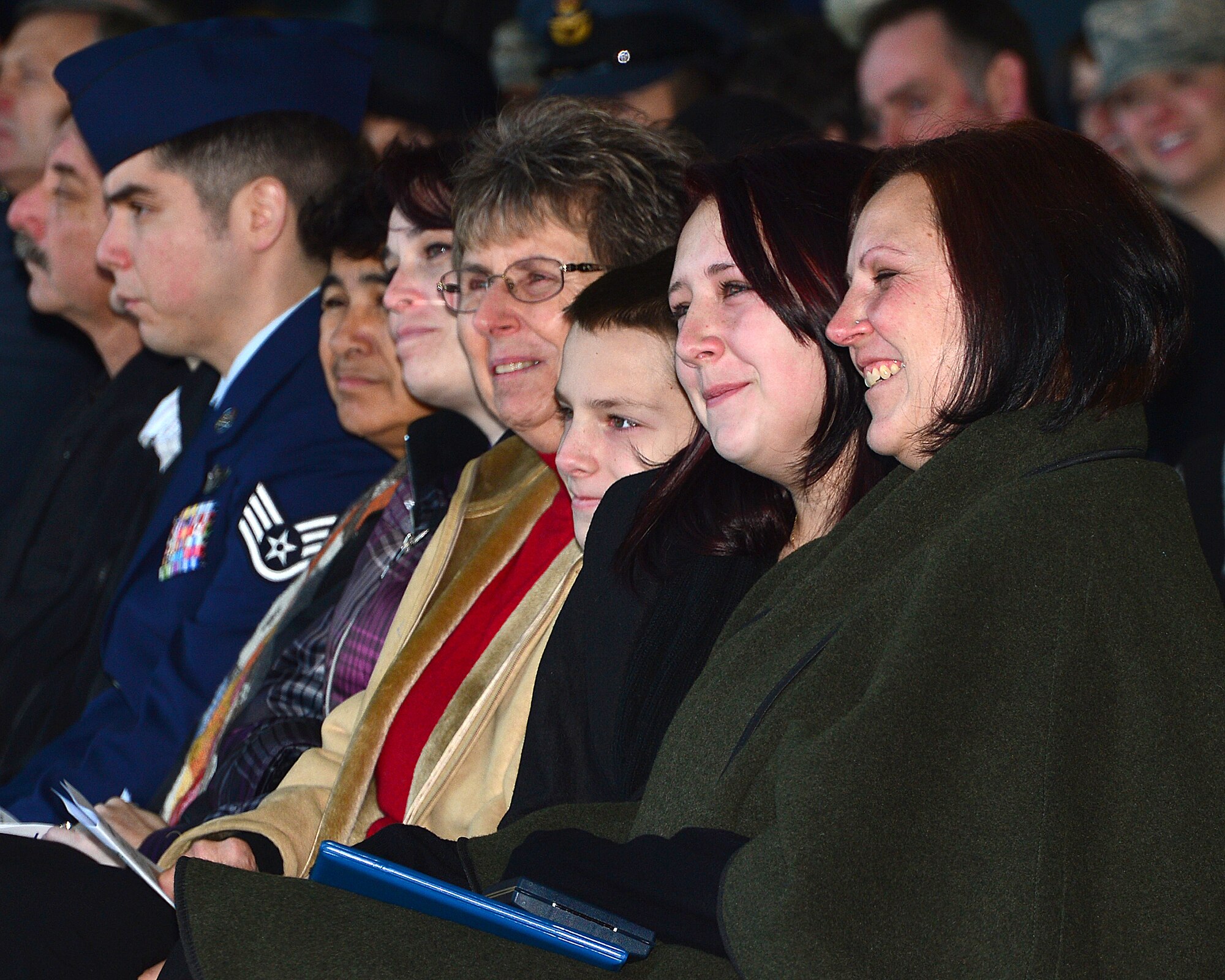 Kim, Michayla and Logan, family members of Tech. Sgt. Dale Mathews, 56th Rescue Squadron special mission aviator, smile as a fond memory is told at a memorial service Jan. 17, 2014. The memorial service was held to honor Capt. Sean Ruane, Capt. Christopher Stover, Tech. Sgt. Dale Mathews and Staff Sgt. Afton Ponce, 56th Rescue Squadron, who were killed during an HH-60G Pave Hawk helicopter crash while performing a low-level training mission on the North Norfolk coast on Jan. 7, 2014. (U.S. Air Force photo by Staff Sgt. Stephanie Mancha/Released)