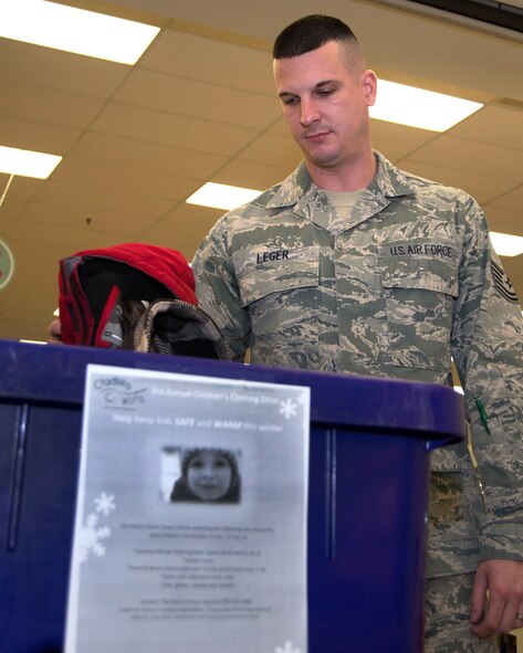 Technical Sgt. Richard Leger, 66th Force Support Squadron, collects donations from a drop box at the Main Base Exchange Jan. 17. Leger and other Honor Guard members are collecting gently used children's clothing to donate to Cradles to Crayons as part of a clothing drive taking place through Jan. 27. Cradles to Crayons provides children from birth through age 12 living in homeless or low-income situations with the essential items they need to thrive at home, school and at play. Donations can be made at the drop box outside the Base Exchange entrance. (U.S. Air Force photo by Mark Herlihy)
