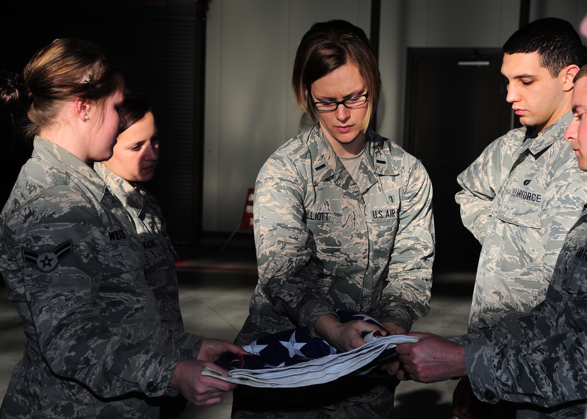 First Lt. Sharon Elliott, 14th Flying Training Wing Honor Guard Officer in Charge, demonstrates how to fold the American flag during Honor Guard practice Jan. 15 at the Walker Center. (U.S. Air Force Photo/Airman 1st Class Stephanie Englar)