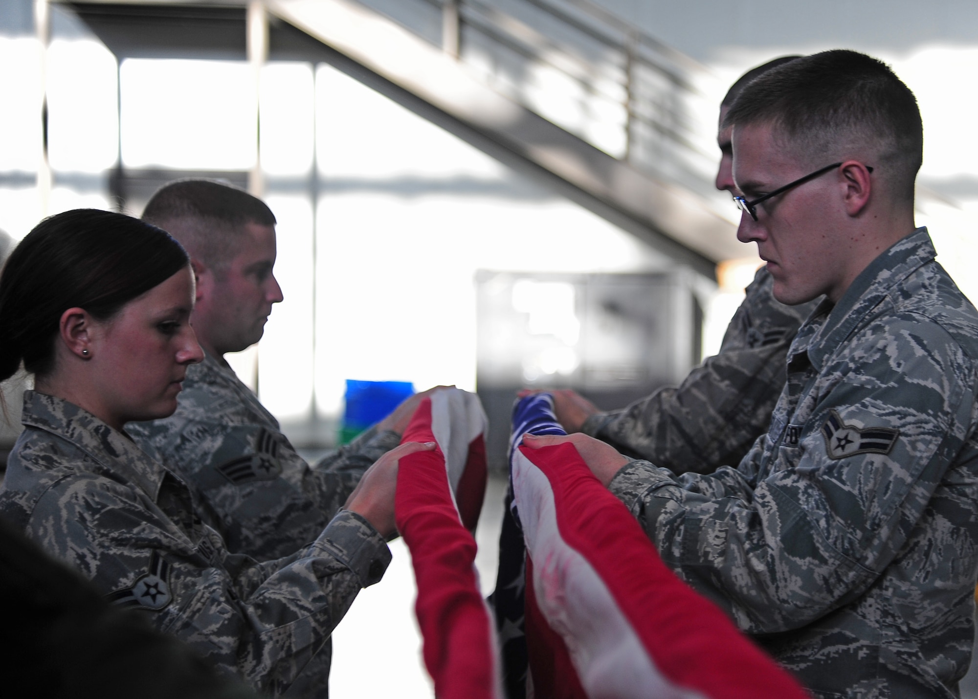 Airman 1st Class Taylor Varone, 14th Operations Support Squadron, and Airman 1st Class Patrick Caffrey, 14th Force Support Squadron, practice folding the American flag during Honor Guard practice Jan. 15 at the Walker Center. (U.S. Air Force Photo/Airman 1st Class Stephanie Englar)