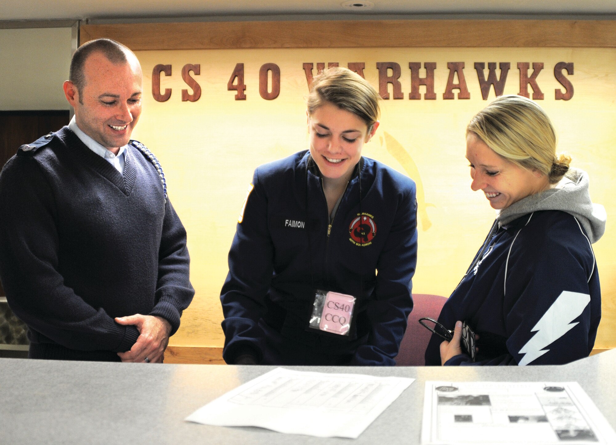 Tech. Sgt. Leslie Cook (left), an Academy Military Trainer for Cadet Squadron 40, speaks with Cadets 3rd Class Caitlin Faimon and Jenna Tasic (right) at their squadron's information desk Jan. 15. Cook used his Self Aid Buddy Care training to aid two patrons in two Colorado Springs stores Nov. 29. (U.S. Air Force photo/Carol Lawrence) 
