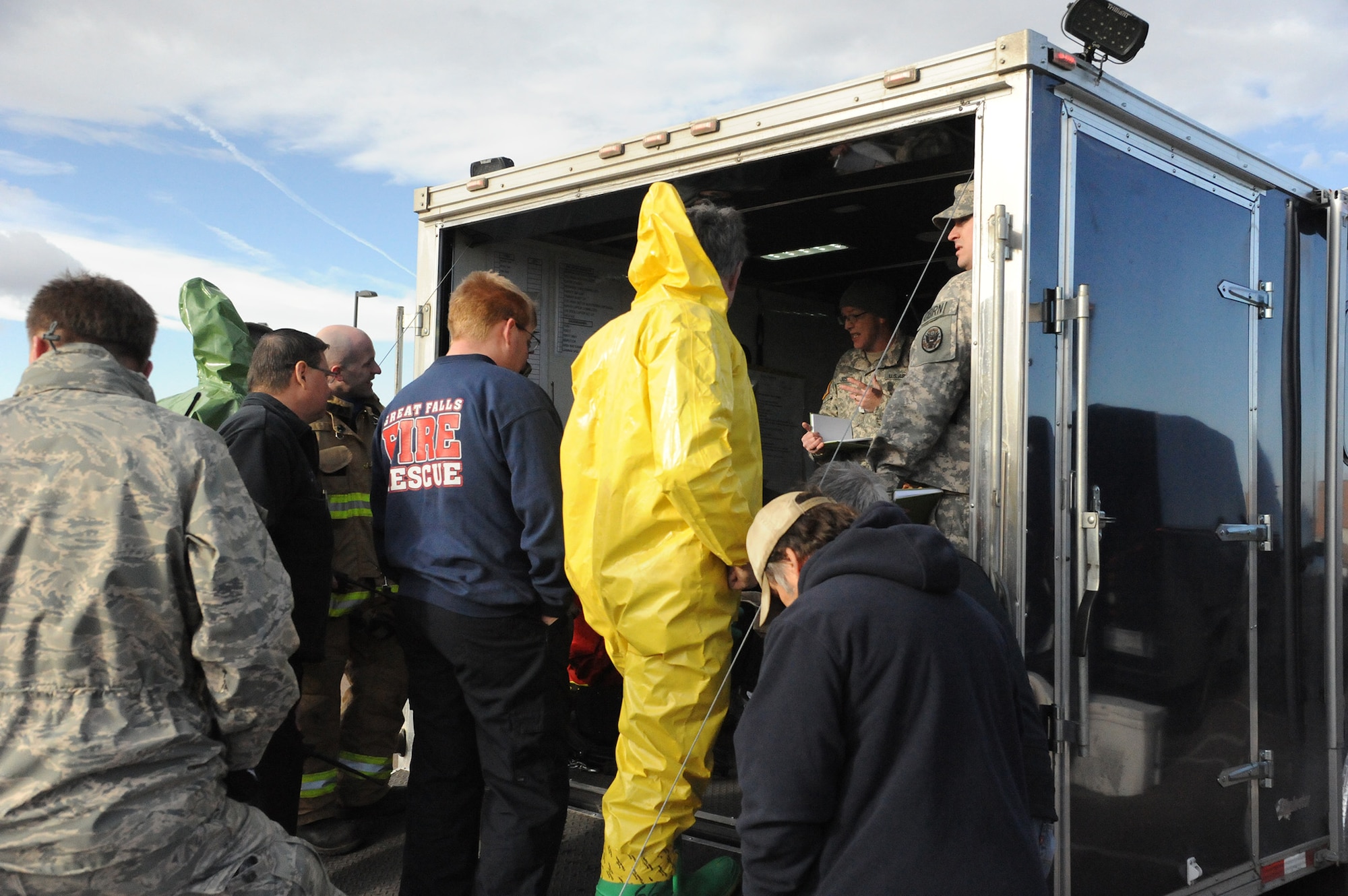 Members of the Great Falls Fire Rescue and Regional Hazardous Materials Team, Montana Army National Guard’s 83rd Civil Support Team, Montana Air National Guard and Malmstrom Air Force Base gather around the 83rd CST trailer for a pre-entry briefing during a joint training exercise at the MTANG on Jan. 13. The event exercised each organization’s ability to communicate and work with unity of effort to resolve a possible terrorist use of chemical, biological, radiological or nuclear materials. (U.S. Air Force photo/Senior Airman Cortney Paxton)