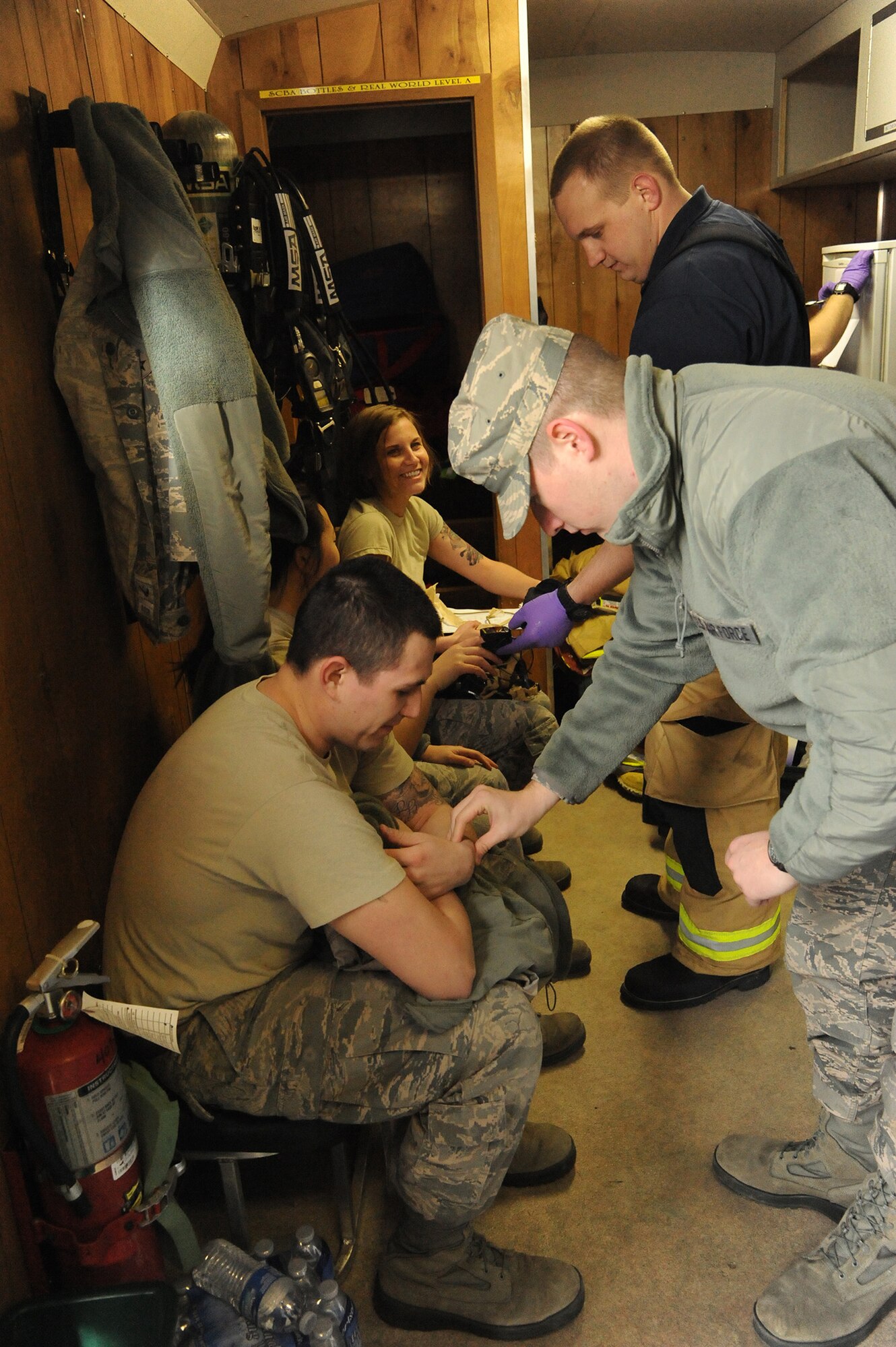 Airman 1st Class Sean McLarnon, 341st Medical Operations Squadron bioenvironmental engineer technician (right), takes the pulse of Airman 1st Class Joel Rogel, 341st MDOS bioenvironmental engineer technician, following his participation in a simulated chemical incident exercise Jan. 13. A Montana Air National Guard firefighter checks the vital signs of Rogel’s Chemical, Biological, Radiological and Nuclear Emergency Response Force teammates in the background.  (U.S. Air Force photo/Senior Airman Cortney Paxton)