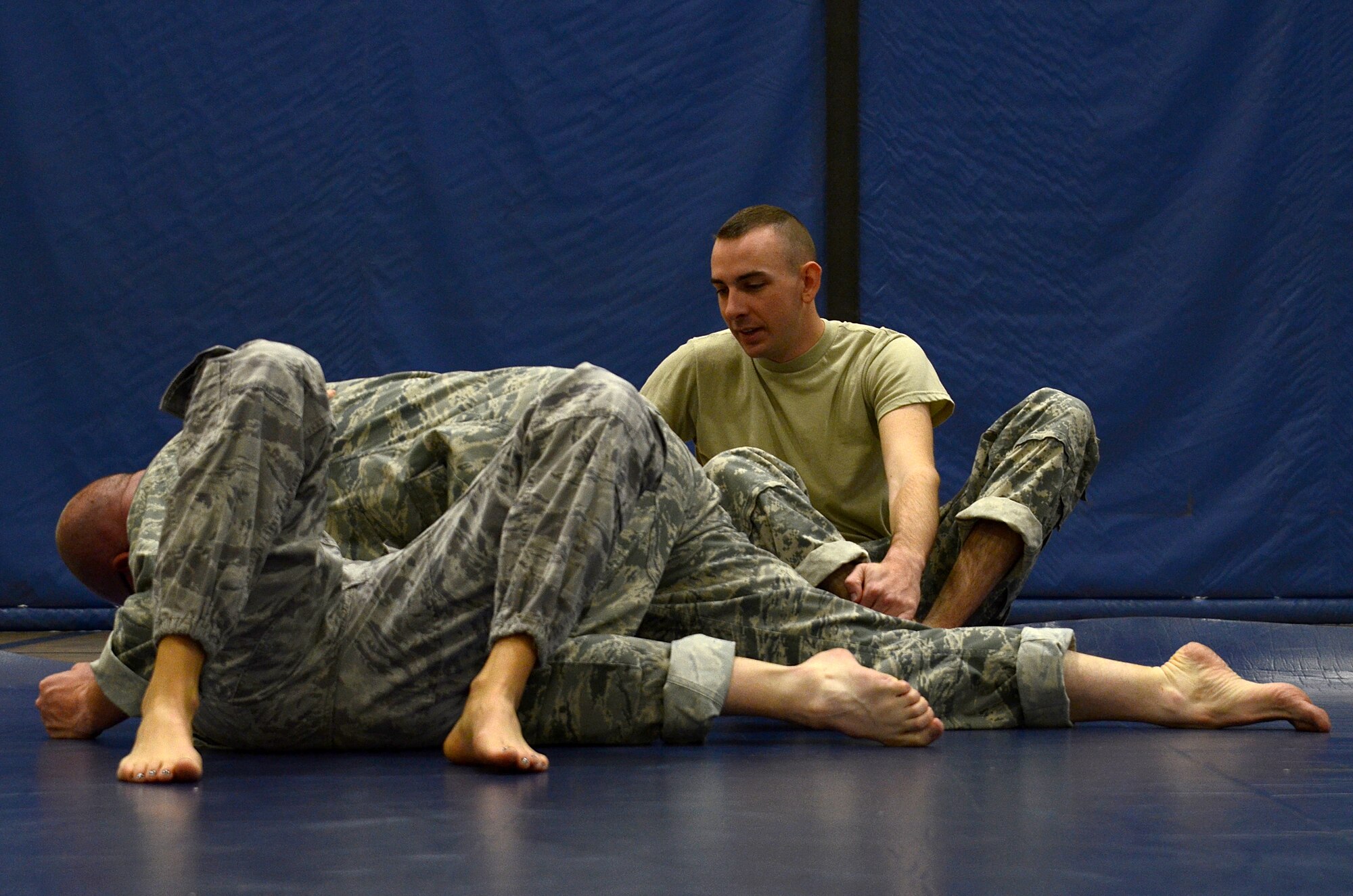 Spc. Charles Welling, assigned to the 1st Battlefield Coordination Detachment, monitors two students  practice ground grappling during the Modern Army Combatives Program (MACP) Basic Combatives Course Level 1 at the Benko Fitness Center on Davis-Monthan AFB, Ariz., Jan. 13, 2014. MACP is a 40-hour course that focuses on three phases of basic fight strategy; close the distance, gain the dominate position, and how to finish the fight. (U.S. Air Force photo by Staff Sgt. Heather R. Redman/Released) 
