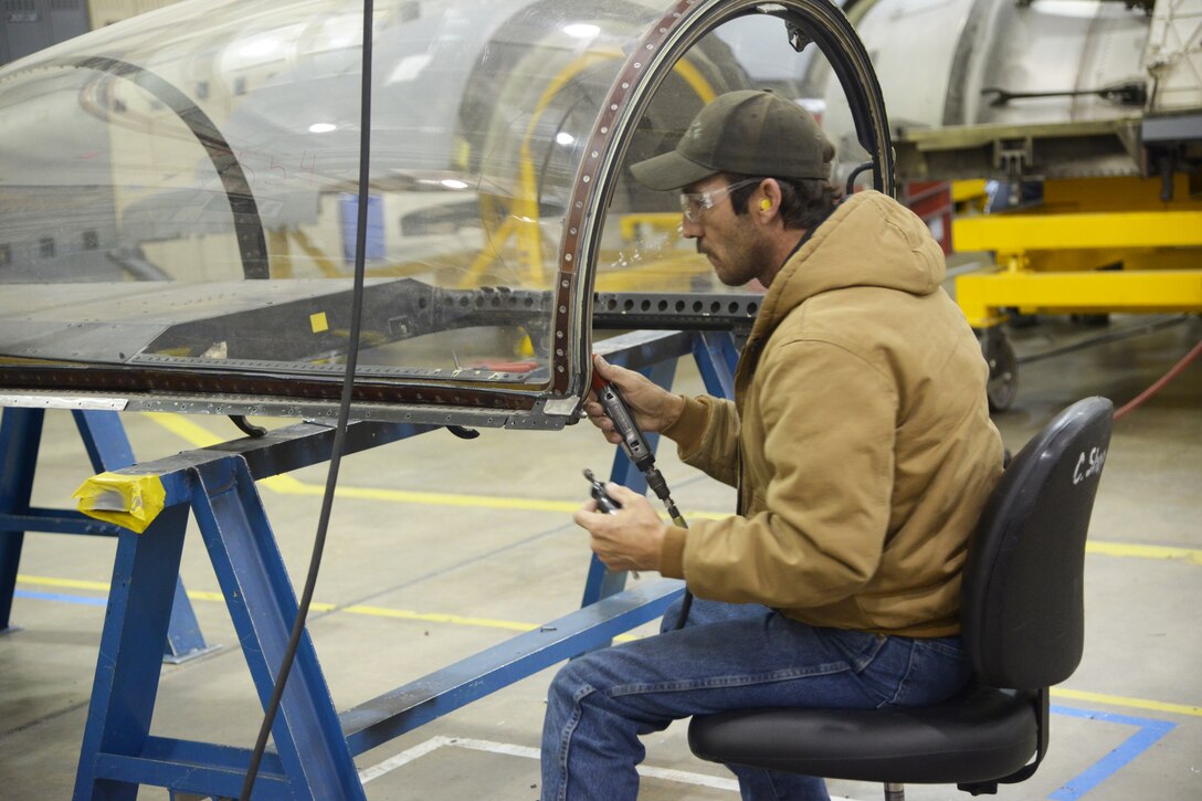 Clint Kinard, 572nd Commodities Maintenance Squadron, tears down a single seat canopy before it goes to hull blast to remove scratches and marks. (U.S. Air Force  photo by Ray Crayton)