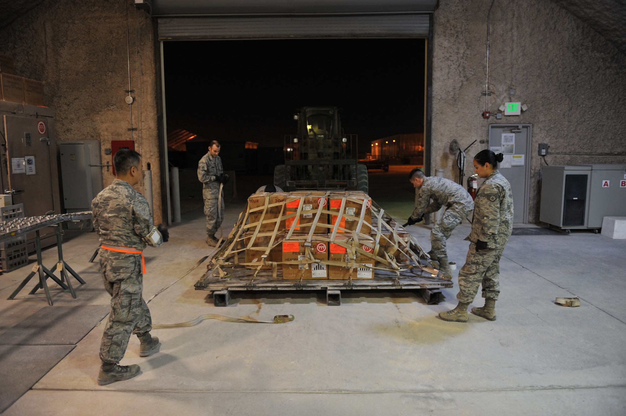 The 379th Expeditionary Medical Group Blood Transshipment Center team tightens the cargo net on a blood product shipment at Al Udeid Air Base, Qatar, Jan. 17, 2014. The BTC serves as the central point for storage and inventory assessment of all blood products in Central Command’s area of responsibility. The BTC ships an average of 600 blood products weekly supporting 43 medical treatment facilities throughout the AOR. (U.S. Air Force photo by Master Sgt. David Miller)