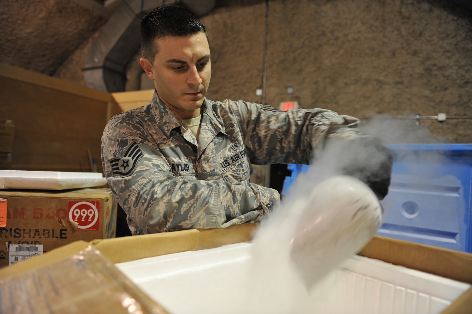 Staff Sgt. Andrew Taylor loads dry ice into a cooler for transport at the 379th Expeditionary Medical Group Blood Transshipment Center, Al Udeid Air Base, Qatar, Jan. 17, 2014. The BTC is the sole source for dry ice in Central Command’s area of responsibility. The BTC receives six tons of dry ice and ships four tons monthly to blood supply detachments. The dry ice is essential for assuring that frozen blood products are safely distributed to outlying forward operating bases. Taylor is a medical logistics technician deployed from Joint Base Langley-Eustis, Va., and is a Hopatcong, N.J., native. (U.S. Air Force photo by Master Sgt. David Miller)