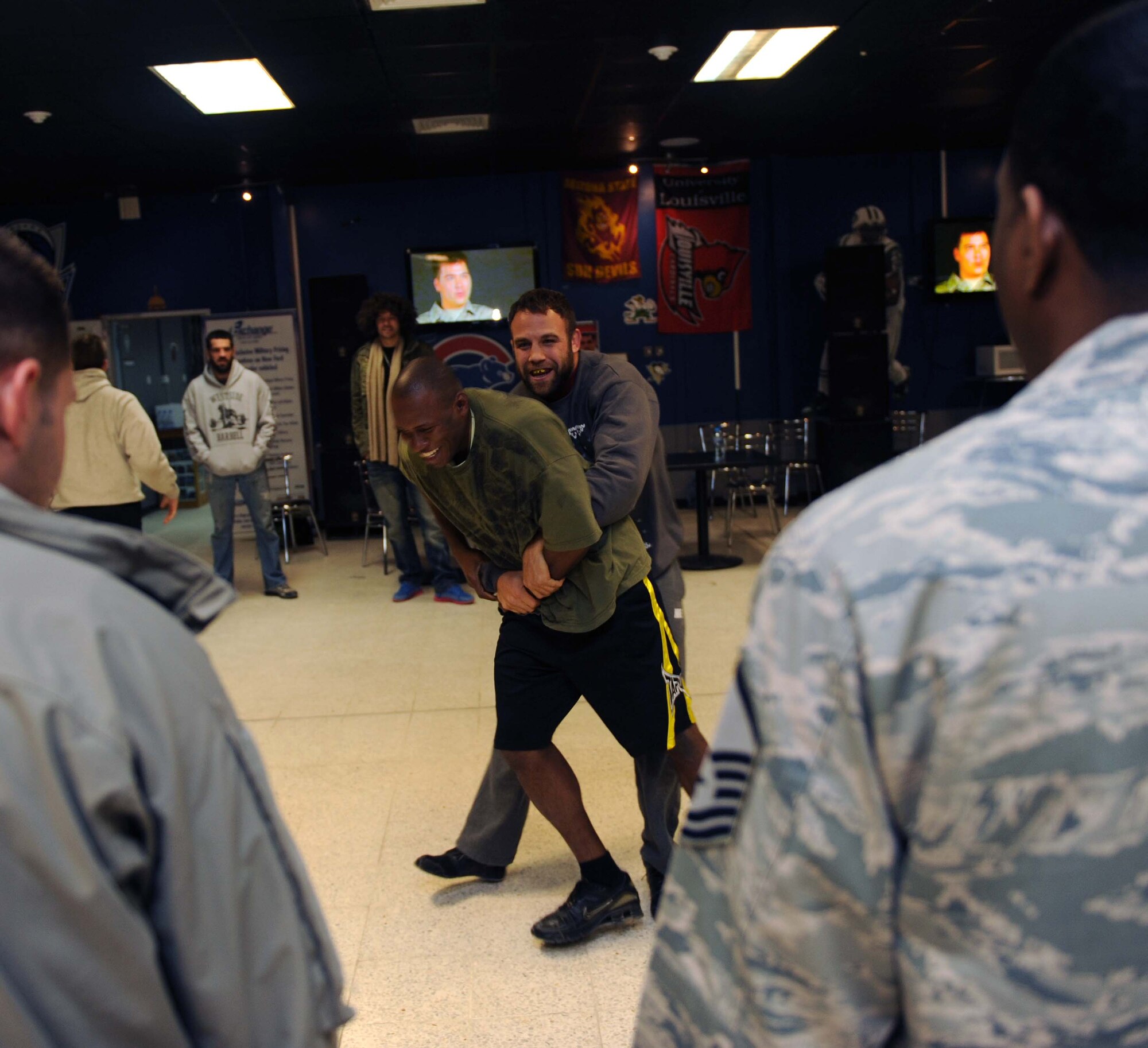 Tech Sgt. Wilsondo Alteus, 386th Expeditionary Force Support Squadron deployment control center liaison officer, takes on his favorite mixed martial arts fighter, Tom Lawlor, during Lawlor’s visit at the Drop Zone recreational facility.  Lawlor met with deployed Airmen while on a Department of Defense Armed Force Entertainment Southwest Asia tour of The Rock. Alteus is deployed from McGuire Air Force Base, N.J., and a native of Royal Palm Beach, Fla. (U.S. Air Force photo by Senior Airman Desiree W. Moye)