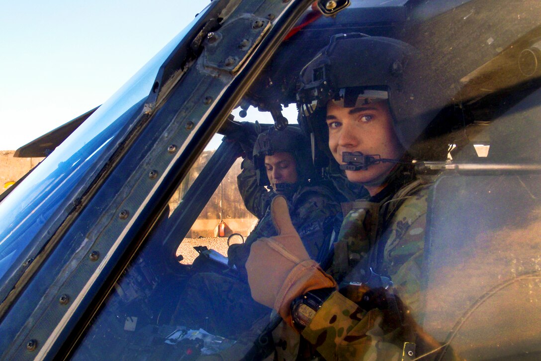 U.S. Army Chief Warrant Officer 2 Bryce Yarbrough, foreground, gives a