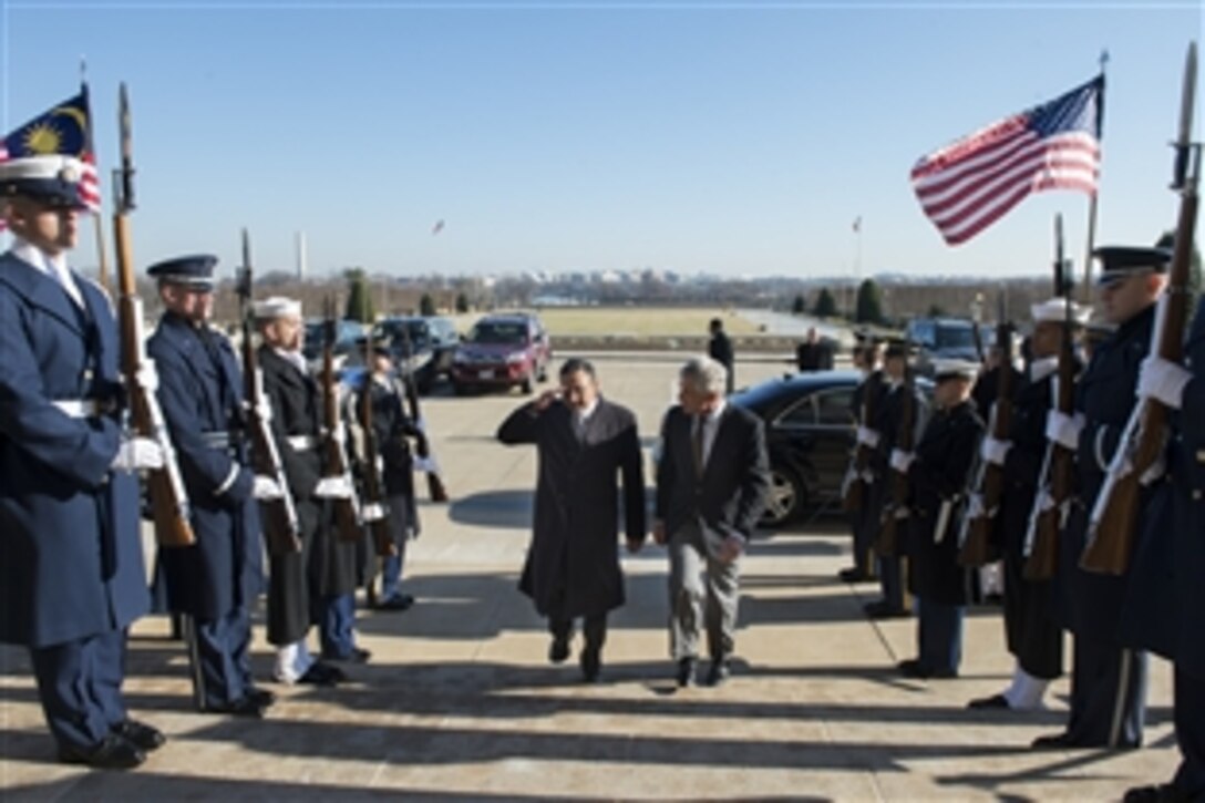 U.S. Defense Secretary Chuck Hagel, right, walks with Malaysian Defense Minister Hishammuddin Tun Hussein through an honor cordon at the Pentagon, Jan. 17, 2014. The two defense leaders met to discuss issues of mutual importance.
