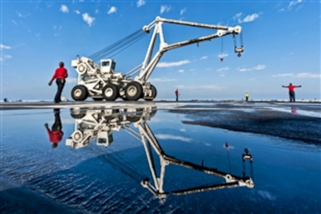 U.S. sailors assigned to the crash and salvage team transport a mobile salvage crane on the flight deck of the aircraft carrier USS Harry S. Truman in the U.S. 5th Fleet area of responsibility, Jan. 15, 2014. The  Truman is conducting maritime security operations and supporting theater security cooperation efforts.