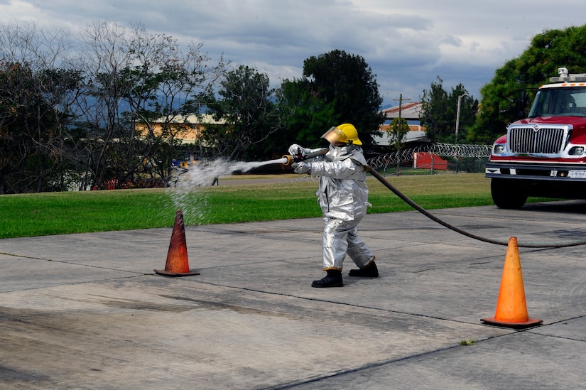 A member of a Honduran fire brigade fires a stream of water from a fire hose during a fire muster hosted by the firefighters of Joint Task Force-Bravo's 612th Air Base Squadron, Jan. 16, 2014.  Thirty members of local Honduran fire brigades and volunteer fire departments participated in the fire muster, which served to bring U.S. and Honduran firefighters together to build camaraderie, engage in training, and take part in friendly competition.  (Photo by Martin Chahin)