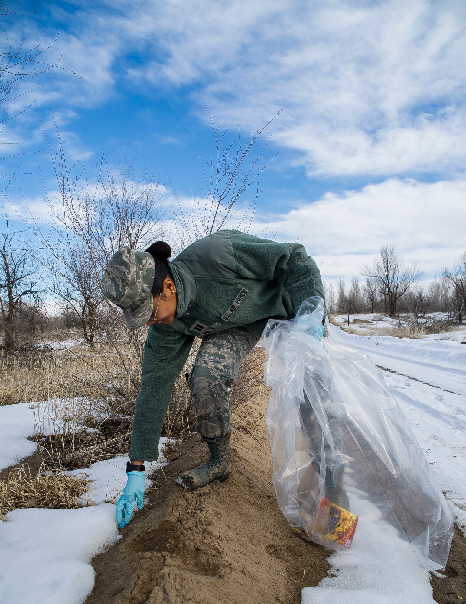 Capt. Loren Hulen, 376th Air Expeditionary Wing sexual assault response coordinator, picks up trash during the Martin Luther King Day of Service Walk at Transit Center at Manas, Kyrgyzstan, Jan. 15, 2014. More than 30 members of the transit center banded together to clean up a running trail located within the confines of the base. The cleanup was their way of giving back as part of "A Day of Service" to honor King. Hulen is deployed from Barksdale Air Force Base, La., and is a native of Frederick, Md. (U.S. Air Force photo/Senior Airman George Goslin)