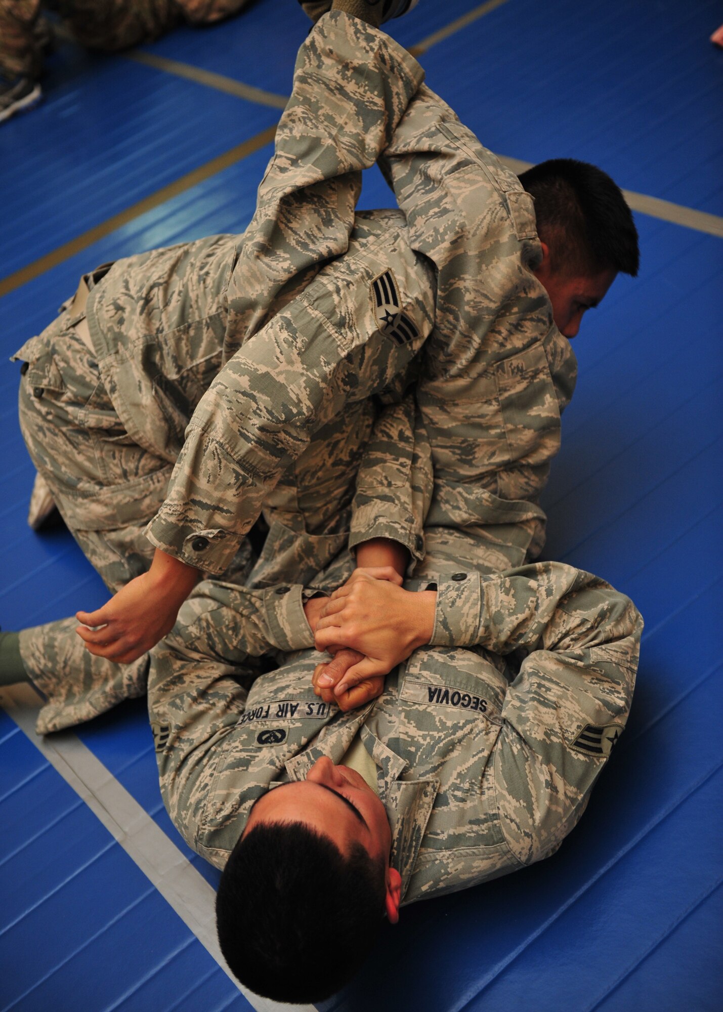 Air Force Senior Airman Robert Segovia, 380th Expeditionary Civil Engineer Squadron heating, ventilation, and air conditioning journeyman, attempts to perform an arm bar on Air Force Senior Airman Elson Valencia, 380 ECES firefighter, during an Air Force combatives class at an undisclosed location in Southwest Asia, Jan. 10, 2014. (U.S. Air Force photo by Staff Sgt. Michael Means/Released)