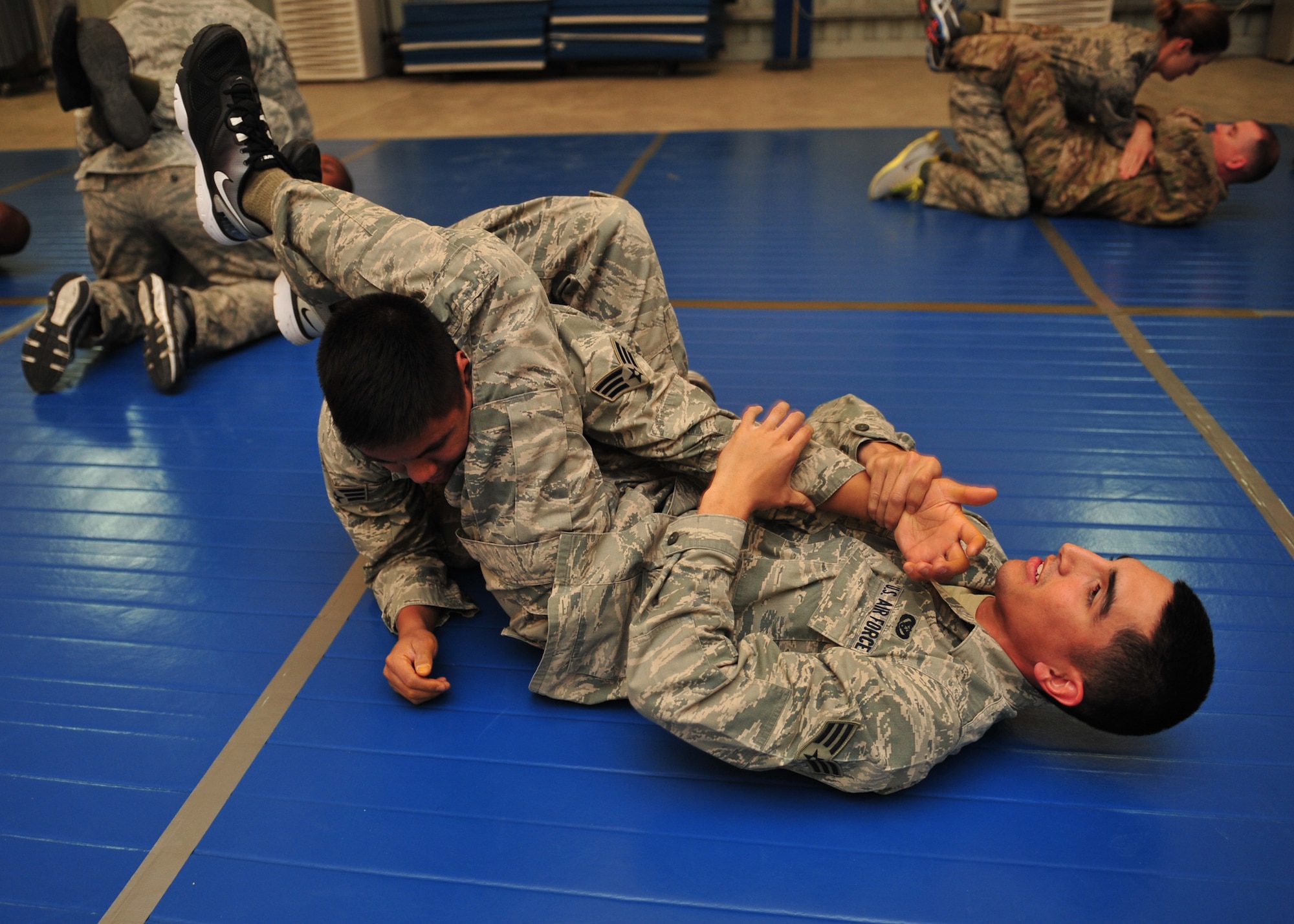 Air Force Senior Airman Robert Segovia, 380th Expeditionary Civil Engineer Squadron heating, ventilation, and air conditioning journeyman, attempts to perform an arm bar on Air Force Senior Airman Elson Valencia, 380 ECES firefighter, during an Air Force combatives class at an undisclosed location in Southwest Asia, Jan. 10, 2014. (U.S. Air Force photo by Staff Sgt. Michael Means/Released)