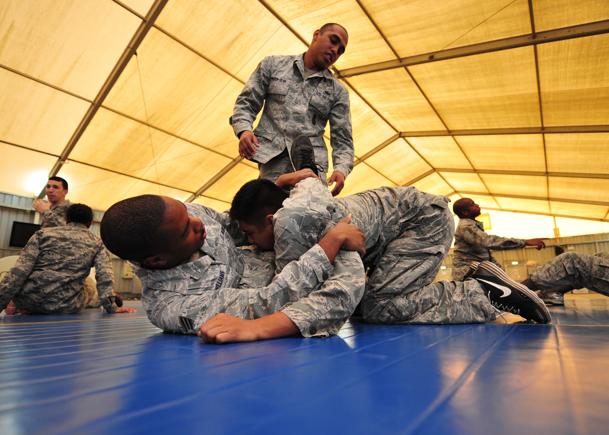 Staff Sgt. Jeffrey Johnson-Dean, an Air Force combatives instructor assigned
to 380 Air Expeditionary Wing Check Six, observes as students practice moves taught
during the Air Force combatives course at an undisclosed location, Jan. 10, 2014. The course consists of stikes, joint manipulation, vascular chokes, escapes, combos and
drills to give students tools to protect themselves in a fight. (U.S. Air Force photo by Staff Sgt. Michael Means/Released)