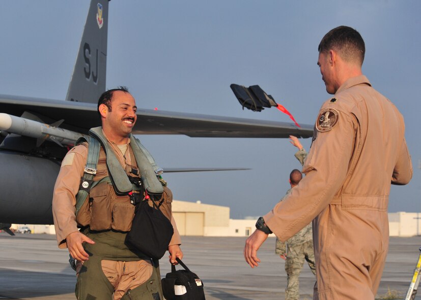 Air Force Lt. Col. Todd Dyer, 335th Expeditionary Fighter Squadron commander, congratulates Air Force Maj. “Dozer,” 335th EFS weapon systems officer,  after completing his 1,000th combat flying hour at an undisclosed location in Southwest Asia, Jan. 12, 2014. (U.S. Air Force photo by Staff Sgt. Michael Means/Released)