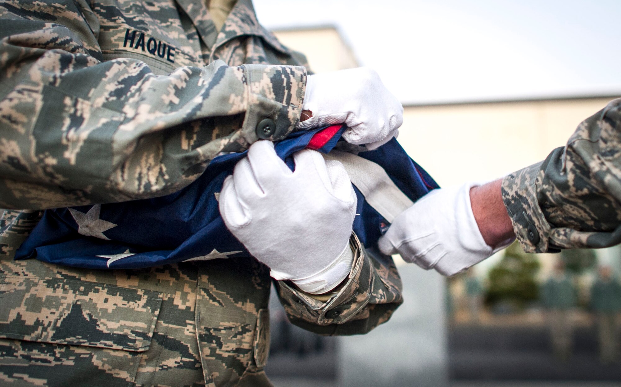 Senior Airman Ariful Haque,  374th Civil Engineer Squadron, a member of the Yokota Air Base honor guard, lowers the U.S.  flag during a retreat ceremony Jan. 17, 2014 at Yokota Air Base, Japan. The retreat ceremony both signals the end of the official duty day and serves as a ceremony for paying respect to the flag.  (U.S. Air Force Photo by Staff Sgt Stacy Moless) 