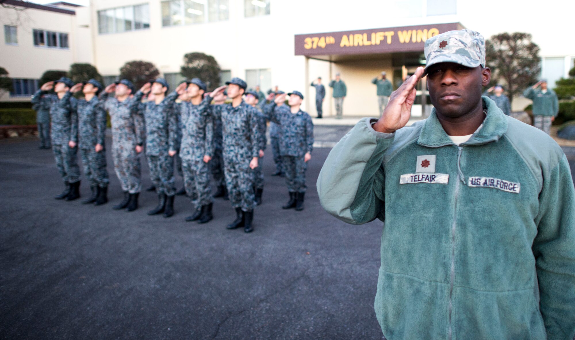 Maj. Tywann Telfair, 374th Civil Engineer Squadron, salutes during a retreat ceremony Jan. 17, 2014 at Yokota Air Base, Japan.  This retreat is the first ever bilateral wing retreat with 12 Air Force members and 12 Japanese Air Self-Defense Force members in formation. (U.S. Air Force Photo by Staff Sgt Stacy Moless) 