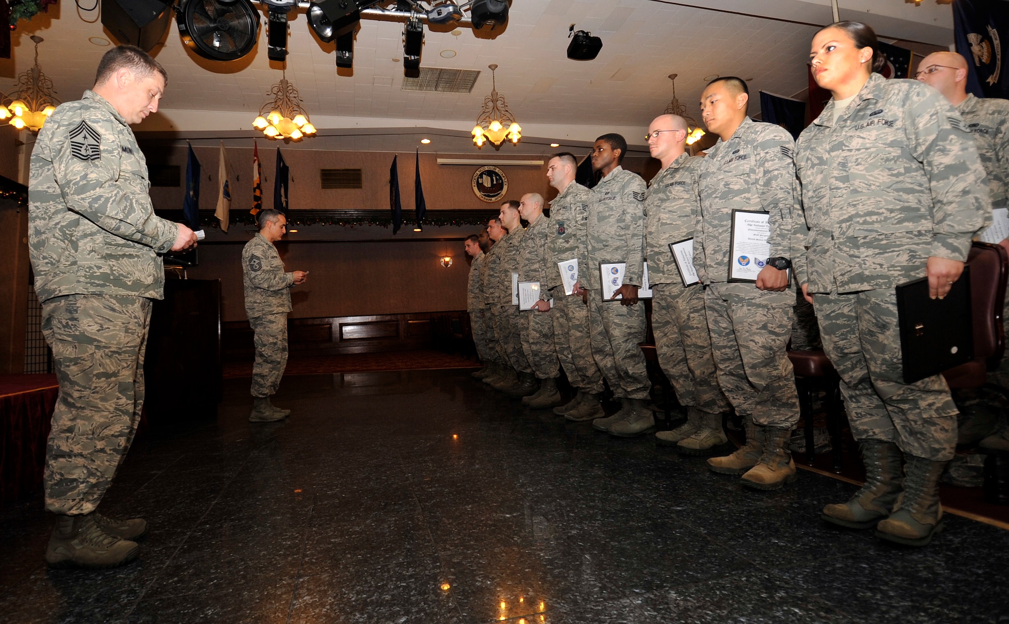 U.S. Air Force Chief Master Sgt. Joseph Montgomery, 353rd Special Operations Group command chief, and Chief Master Sgt. Ramon Colon-Lopez, 18th Wing command chief, induct newly promoted staff sergeants during a quarterly NCO induction ceremony at the Rocker NCO Club on Kadena Air Base, Japan, Jan. 15, 2014. The ceremony celebrates and recognizes those who have recently put on the rank of staff sergeant and have reached the status of NCO. (U.S. Air Force photo by Naoto Anazawa)