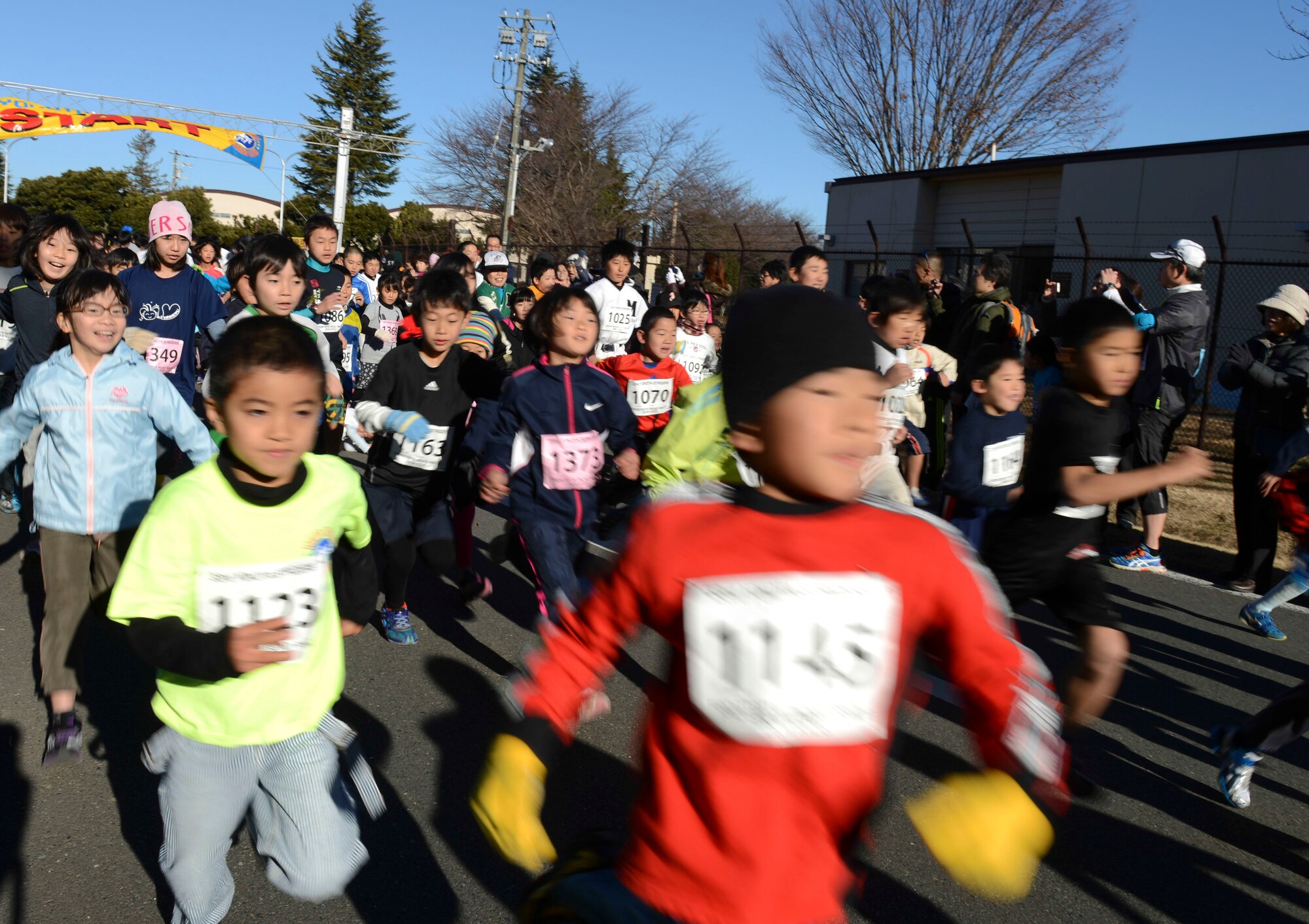 Children participating in the kids 2K run as part of the annual Frostbite Run race past the starting line at Yokota Air Base, Japan, Jan.19, 2014.  Children had the opportunity to run by themselves or with their family in the other 2K race offered. (U.S. Air Force photo by Airman 1st Class Meagan Schutter/Released)