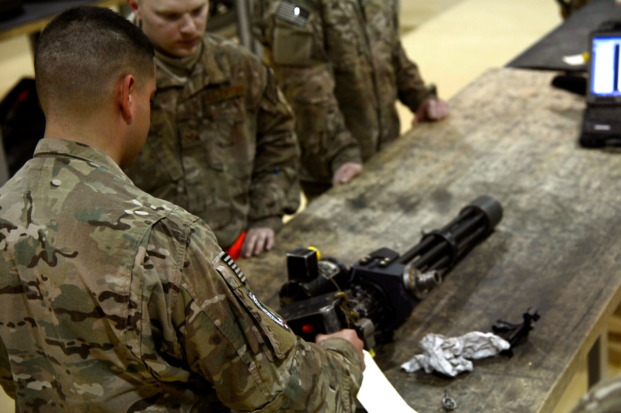 U.S. Air Force Tech. Sgt. Vincent Lopez, 83rd Expeditionary Rescue Squadron weapons expeditor, trains Airmen assigned to the 455th Expeditionary Maintenance Squadron armament shop at Bagram Airfield, Afghanistan, Jan. 19, 2014. Lopez trained the Airmen on the GAU 18 machine gun and GAU 2 mini gun, found on the HH-60G Pave Hawk. Lopez is deployed from the 718th Aircraft Maintenance Squadron at Kadena Air Base, Japan, and is a native of El Paso, Texas. (U.S. Air Force photo by Senior Airman Kayla Newman/Released)

