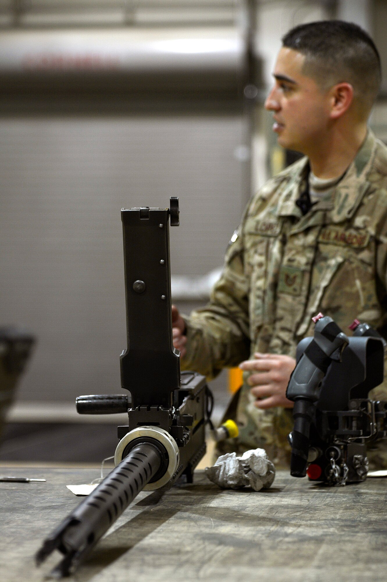 U.S. Air Force Tech. Sgt. Vincent Lopez, 83rd Expeditionary Rescue Squadron weapons expeditor, explains the GAU 2 mini gun during a training session to Airmen assigned to the 455th Expeditionary Maintenance Squadron armament shop gun at Bagram Airfield, Afghanistan, Jan. 19, 2014. . Lopez led a training session to familiarize the Airmen with the weapons on HH-60G Pave Hawks. Lopez is deployed from the 718th Aircraft Maintenance Squadron at Kadena Air Base, Japan, and is a native of El Paso, Texas. (U.S. Air Force photo by Senior Airman Kayla Newman/Released)