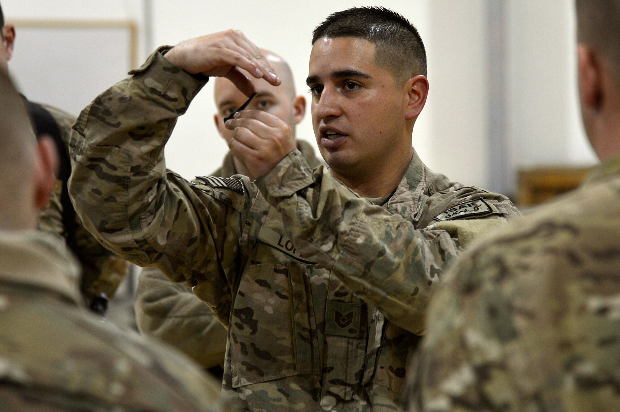 U.S. Air Force Tech. Sgt. Vincent Lopez, 83rd Expeditionary Rescue Squadron weapons lead expeditor, explains a piece of the GAL 18 mini gun to Airmen assigned to the 455th Expeditionary Maintenance Squadron armament shop at Bagram Airfield, Afghanistan, Jan. 19, 2014. Lopez led a training session to familiarize the Airmen with the weapons on HH-60G Pave Hawks. Lopez is deployed from the 718th Aircraft Maintenance Squadron at Kadena Air Base, Japan, and is a native of El Paso, Texas. (U.S. Air Force photo by Senior Airman Kayla Newman/Released)