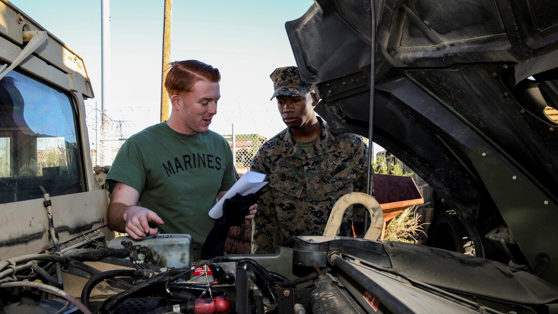 Corporal James R. Kerr, chemical, biological, radiological and nuclear defense specialist, left, instructs Lance Cpl. Dyrell Oliver, supply clerk, both with the 15th Marine Expeditionary Unit, on how to properly inspect fluids on a High Mobility Multipurpose Wheeled Vehicle aboard Camp Pendleton, Calif., Jan. 16, 2014. (U.S. Marine Corps photo by Cpl. Emmanuel Ramos/Released)