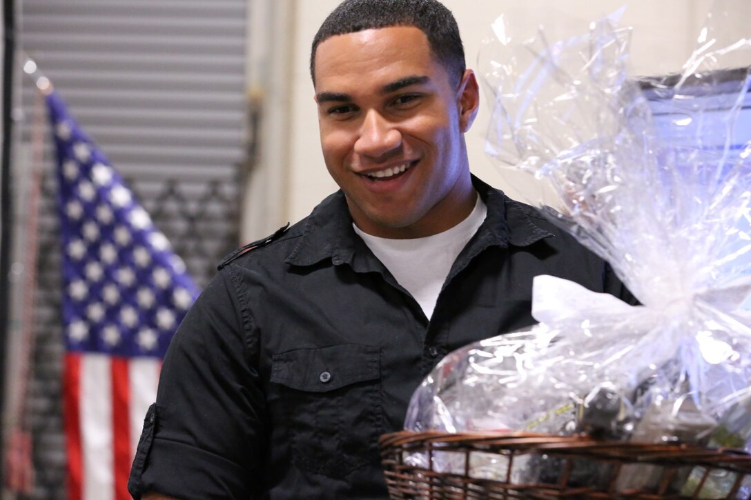 Cpl. Shawn Brakey, a fire support man with 1st Air Naval Gunfire Liaison Company, holds his prize at a town hall meeting aboard Camp Pendleton, Calif., Jan 15. The meeting allowed families to ask questions and get a better sense of ANGLICO’s structure and purpose.