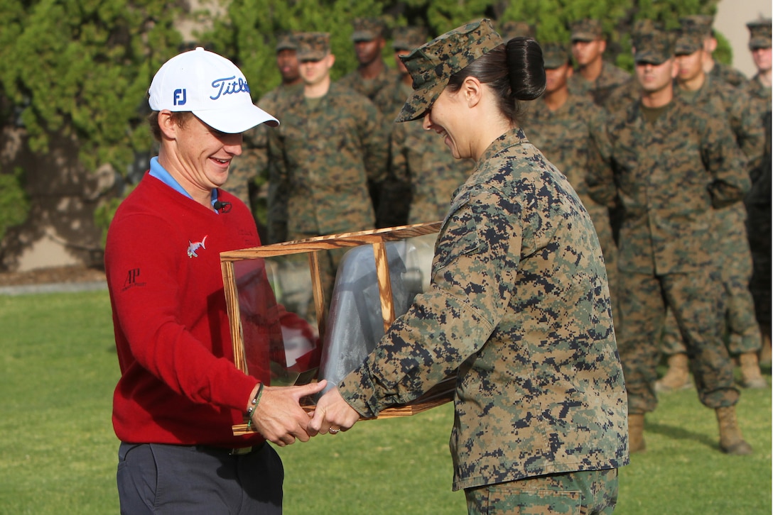 Bud Cauley, a member of the PGA Tour and guest of honor, is presented with a token of appreciation on behalf of the 3rd Marine Aircraft Wing by Cpl. Ciara Winton, a combat engineer with Marine Wing Support Squadron (MWSS) 373, during a morning colors ceremony aboard Marine Corps Air Station Miramar, Calif., Jan. 21. The Daytona Beach, Fla., native established the Bud Cauley Foundation in 2012 to raise awareness and funds for military-related charities and is an active supporter of Birdies for the Brave, another military outreach program. Both Cauley’s grandfather and father served as divers in the Navy.