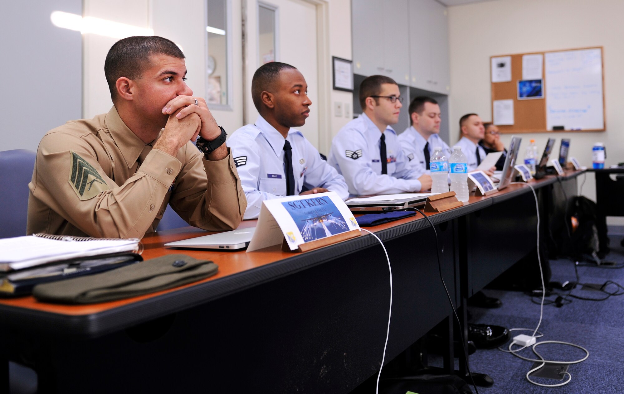 U.S. Marine Corps Sgt. Steven Kern, Marine Corps Air Station Futenma 4th Platoon sergeant, and Airmen from Airman Leadership School Class 14-B listen to a briefing at the Erwin Professional Military Education Center on Kadena Air Base, Japan, Jan. 15, 2014. ALS is the Air Force equivalent to the Marine Corps? Corporals Course and Sergeants Course. This is the second time in Kadena?s history that Marines joined in ALS; the first Marines students to join were in Class 13-D. (U.S. Air Force photo by Naoto Anazawa)