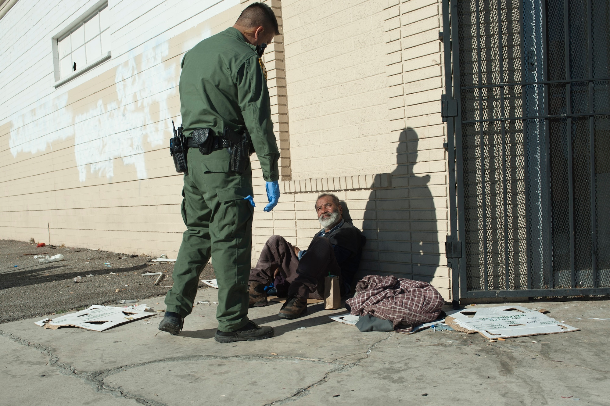 AdAden Ocampogomez, Las Vegas Metropolitan Police Department police officer, questions a homeless man after catching him drinking alcohol on the sidewalk in downtown Las Vegas Jan. 14, 2014. The man, who was a repeat offender, was taken to jail and put into a rehabilitation program. (U.S. Air Force photo by Airman 1st Class Timothy Young)