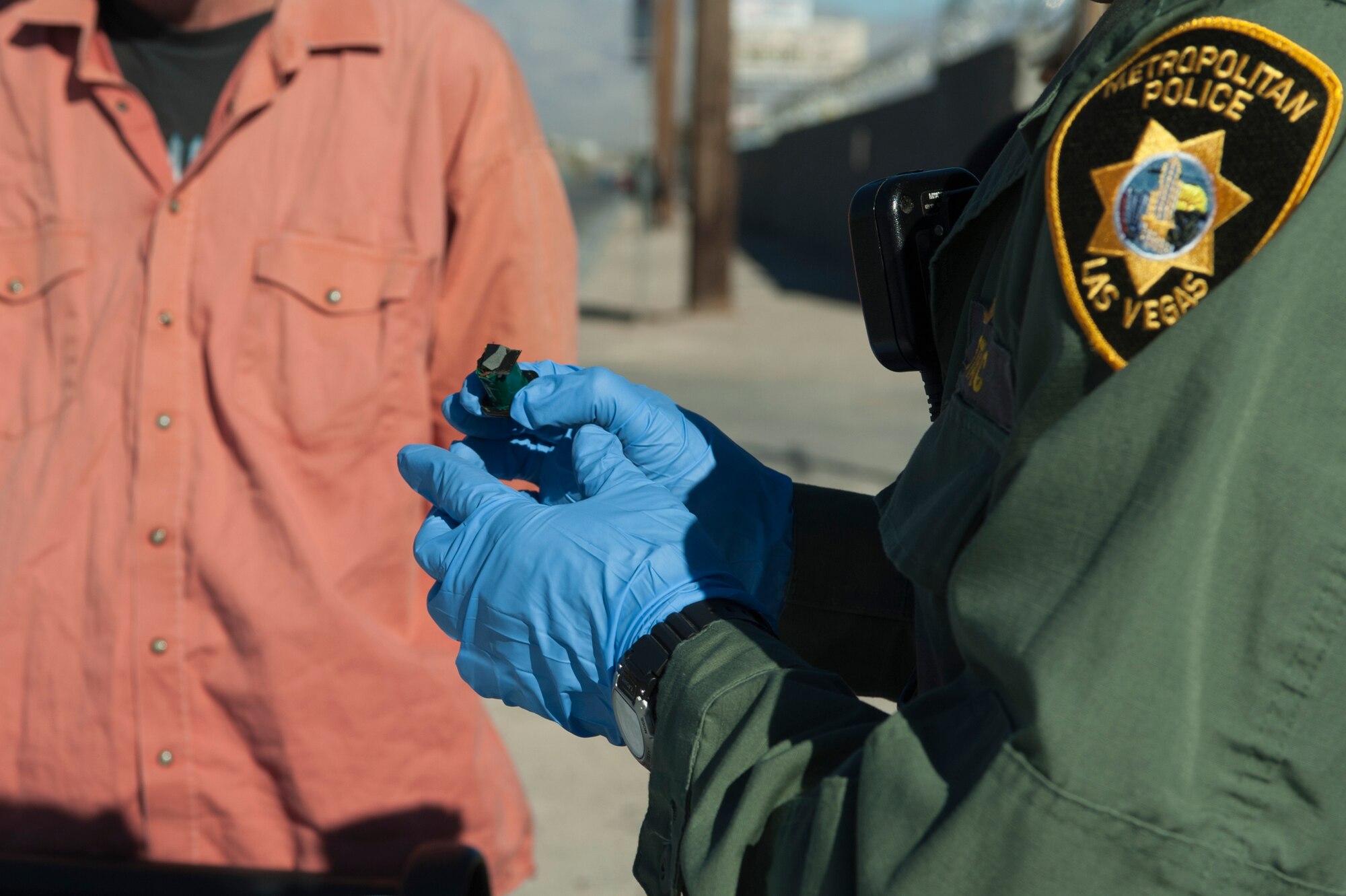 Aden Ocampogomez, Las Vegas Metropolitan Police Department police officer, searches a suspect’s belongings after the suspect hid items upon the officer’s arrival at a downtown location Jan. 14, 2014, in Las Vegas. The suspect was collecting copper wire from discarded electronic parts to sell as scrap.  (U.S. Air Force photo by Airman 1st Class Timothy Young)