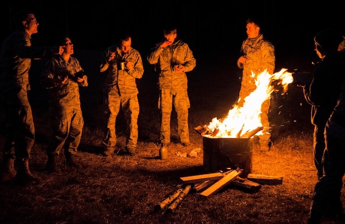 Airmen from the 1st, 2nd and 3rd Combat Camera Squadrons gather around the fire at night during the Ability to Survive and Operate exercise Jan. 15, 2014, at North Auxiliary Air Field, S.C. The 1st Combat Camera Squadron located at Joint Base Charleston, S.C., hosted the Ability to Survive and Operate Exercise from Jan. 6 through 17. (U.S. Air Force photo/ Airman 1st Class Clayton Cupit)
