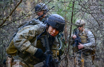 Maj. Mindy Yu, 1st Combat Camera Squadron officer, navigates her team through the woods during the Ability to Survive and Operate exercise Jan. 14, 2014, at North Auxiliary Air Field, S.C. The exercise was organized to sharpen Airmen’s skills and their ability to operate as combat documentation specialists outside the wire. (U.S. Air Force photo/ Airman 1st Class Clayton Cupit)