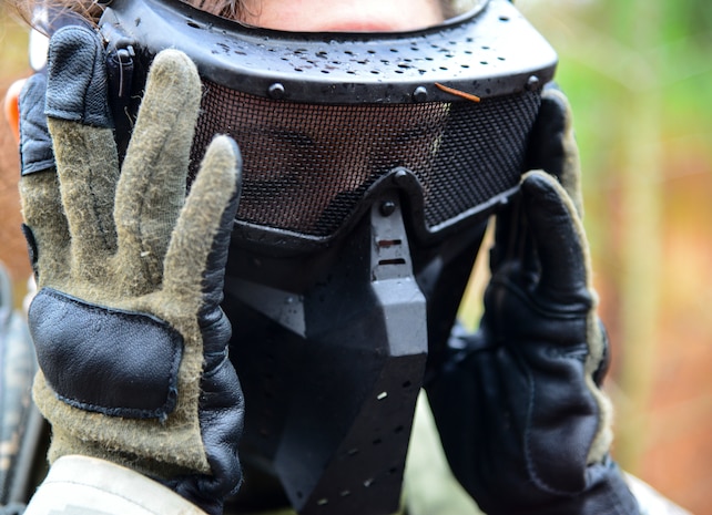Airman Taylor Queen, 2nd Combat Camera Squadron photojournalist, puts on his protective facemask in preparation for a close quarters battle during the Ability to Survive and Operate exercise Jan. 14, 2014, at North Auxiliary Air Field, S.C. The exercise was organized to sharpen Airmen’s skills and their ability to operate as combat documentation specialists outside the wire. (U.S. Air Force photo/ Airman 1st Class Clayton Cupit)