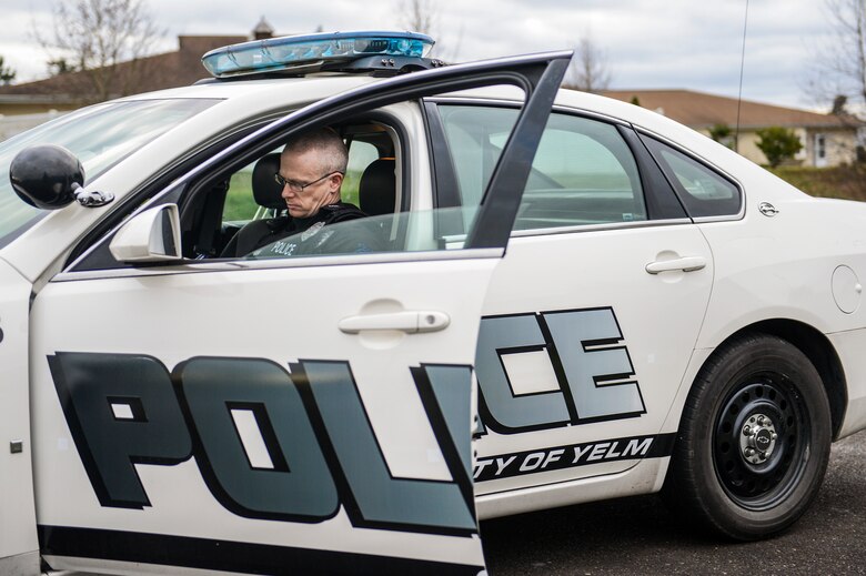 Master Sgt. Phil Ryan, 62nd Airlift Wing Inspector General complaint resolution superintendent, also a reserve police officer at the Yelm Police Department, writes a report after issuing a traffic citation to a speeding motorist, Dec. 14, 2013, in Yelm, Wash. Upon retiring from the Air Force, Ryan plans to work full-time as a police officer. (U.S. Air Force photo/Tech. Sgt. Sean Tobin)