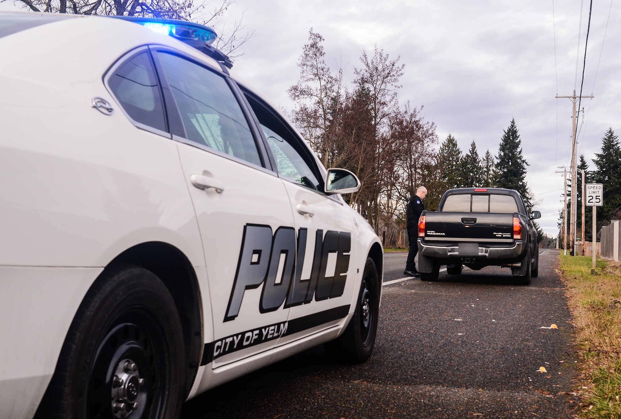 Master Sgt. Phil Ryan, 62nd Airlift Wing Inspector General complaint resolution superintendent, also a reserve police officer at the Yelm Police Department, collects a driver's information following a traffic stop, Dec. 14, 2013, in Yelm, Wash. As a sworn peace officer, Ryan volunteers his free time with police department. (U.S. Air Force photo/Tech. Sgt. Sean Tobin)