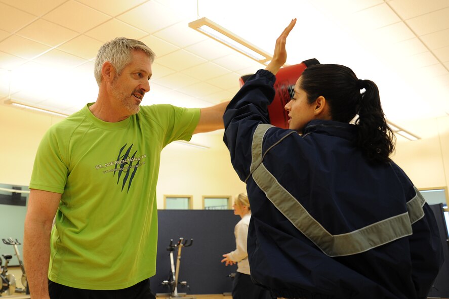 J. Colt, Rape Aggression Defense instructor, teaches Senior Airman Stefania Esquer, a 92nd Comptroller Squadron travel pay technician and RAD participant, different defense tactics during the first RAD course at Fairchild Air Force Base, Wash., Jan. 16, 2014. RAD is a two-day training course where the instructors teach women how to defend themselves from aggressors. (U.S. Air Force photo by Airman 1st Class Janelle Patiño/Released) 
