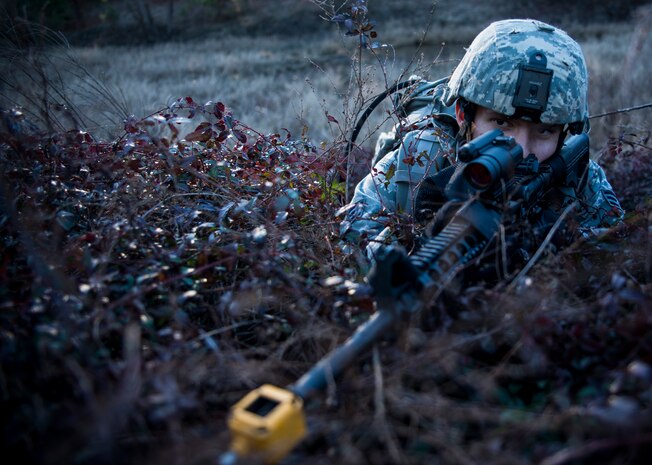 Senior Airman Gregory Cerny, 1st Combat Camera Squadron broadcaster, lies in the prone position while enemy forces attack his team with small arms fire during the Ability to Survive and Operate exercise Jan. 14, 2014, at North Auxiliary Air Field, S.C. The 1st Combat Camera Squadron located at Joint Base Charleston, S.C., hosted the Ability to Survive and Operate Exercise from Jan. 6 through 17. (U.S. Air Force photo/ Senior Airman Dennis Sloan)