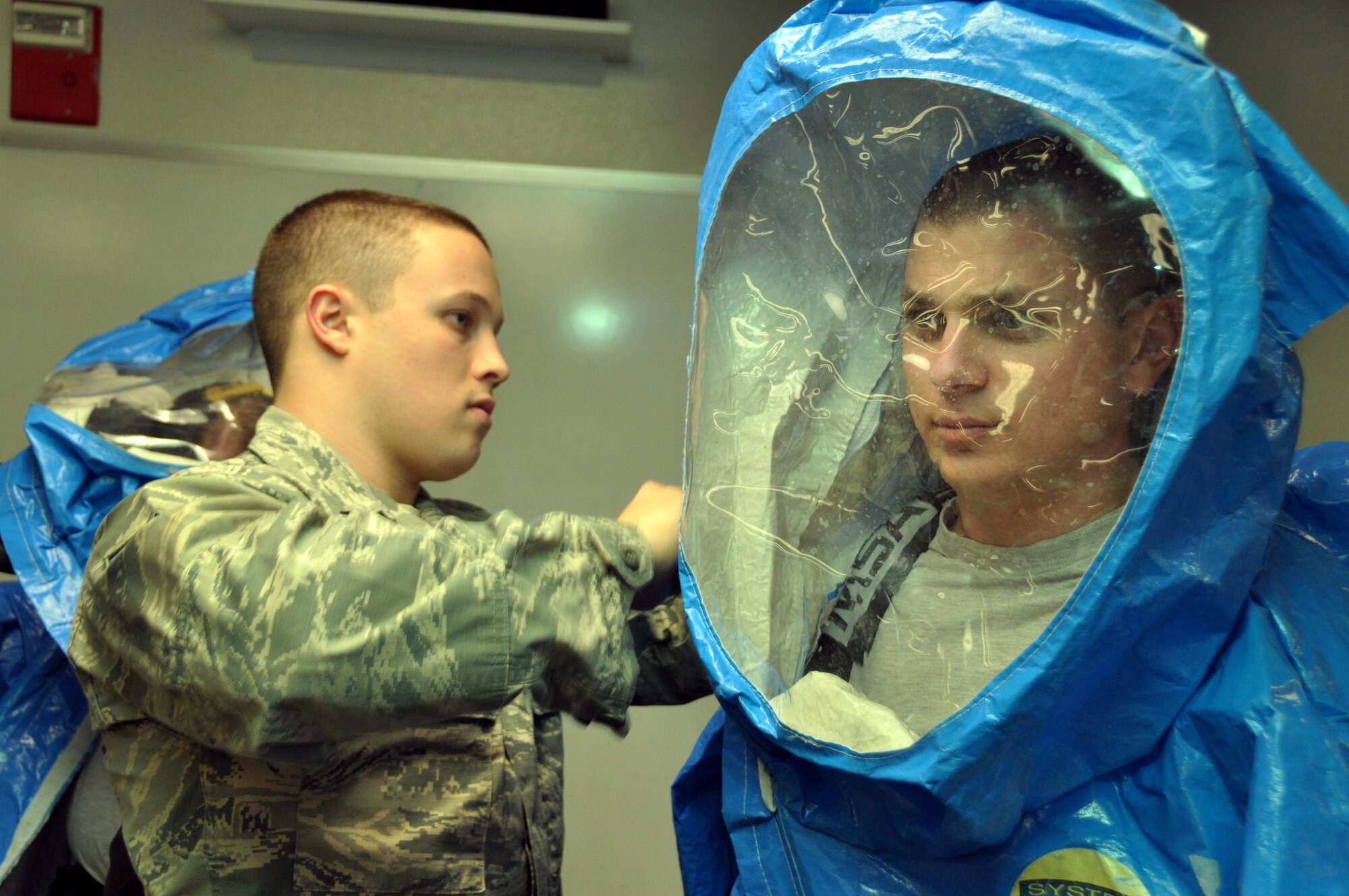 Senior Airman Aaron Wentland, 60th Civil Engineer Squadron emergency management plans and operations specialist, dons protectional gear prior to entering a simulated crime scene in an exercise scenario Monday on Travis.(U.S. Air Force photo/Staff Sgt. Patrick Harrower)