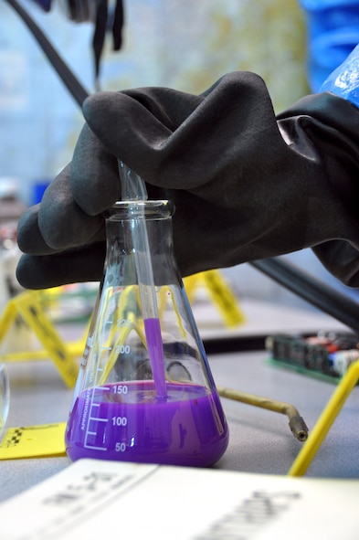 Senior Airman Aaron Wentland, 60th Civil Engineer Squadron emergency management plans and operations specialist, collects a specimen of unidentified liquid at a simulated crime scene to be tested in an exercise scenario Monday on Travis.(U.S. Air Force photo/Staff Sgt. Patrick Harrower)