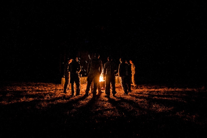 Airmen from the 1st, 2nd and 3rd Combat Camera Squadrons huddle around a fire after completing a full day of tactical training in the field during the Ability to Survive and Operate exercise Jan. 15, 2014, at North Auxiliary Air Field, S.C. The 1st Combat Camera Squadron located at Joint Base Charleston, S.C., hosted the Ability to Survive and Operate Exercise from Jan. 6 through 17. (U.S. Air Force photo/ Senior Airman Dennis Sloan)