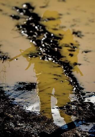 An Airman walks down a mud road during the Ability to Survive and Operate exercise Jan. 14, 2014, at North Auxiliary Air Field, S.C. The exercise was organized to sharpen Airmen’s skills and their ability to operate as combat documentation specialists outside the wire. (U.S. Air Force photo/ Airman 1st Class Clayton Cupit)