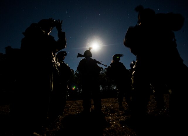 Airmen from the 1st, 2nd and 3rd Combat Camera Squadrons adjust their night vision goggles before going on a night patrol during the Ability to Survive and Operate exercise Jan. 14, 2014, at North Auxiliary Air Field, S.C. The 1st Combat Camera Squadron located at Joint Base Charleston, S.C., hosted the Ability to Survive and Operate Exercise from Jan. 6 through 17. (U.S. Air Force photo/ Senior Airman Dennis Sloan)