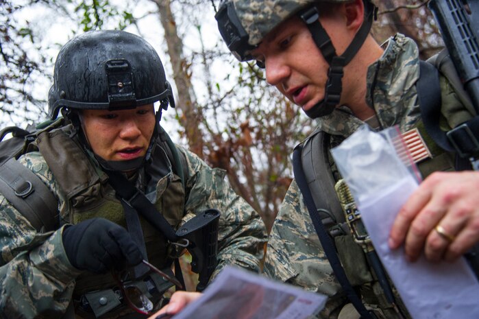 Maj. Mindy Ju, 1st Combat Camera Squadron officer, suggests navigational routes to Senior Airman Gregory Cerny, 1st Combat Camera Squadron broadcaster, during the Ability to Survive and Operate exercise Jan. 14, 2014, at North Auxiliary Air Field, S.C. The exercise was organized to sharpen Airmen’s skills and their ability to operate as combat documentation specialists outside the wire. (U.S. Air Force photo/ Airman 1st Class Clayton Cupit)